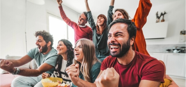 Sports Fans Watching The Game On Dish Tv In The Living Room Dish voice remote on a table